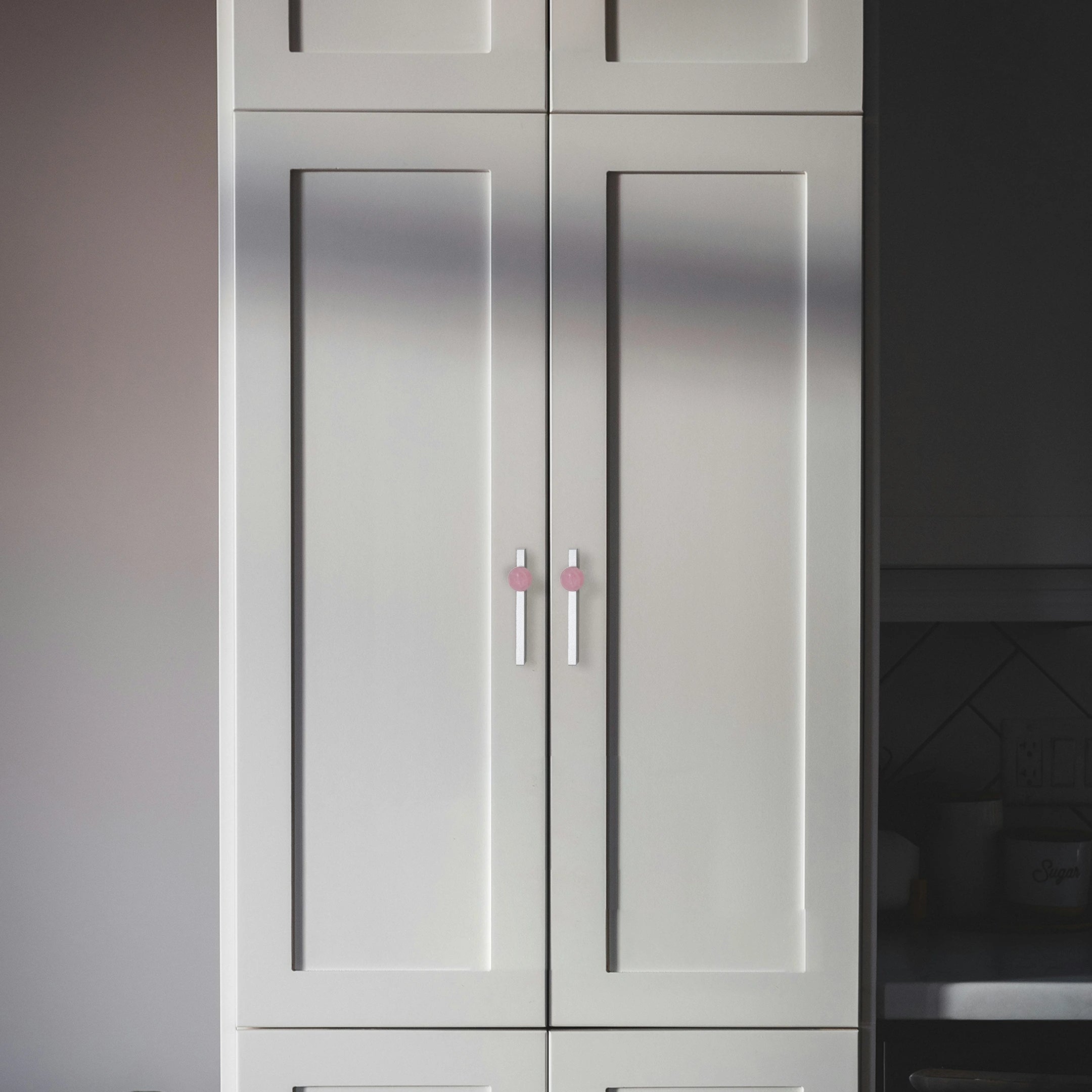Gray cabinet with a single pink handle in a kitchen setting, adding a subtle, stylish accent by Mantara.