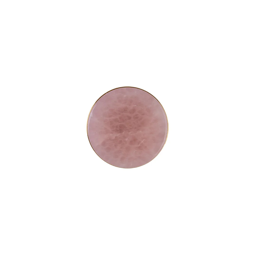 A round rose quartz crystal gemstone cabochon with a polished gold-colored rim, centered on a solid white background.