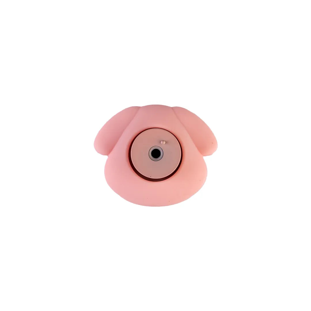 A pink, dog-shaped silicone camera lens protector or cover with a circular center opening, shown against a plain white background.