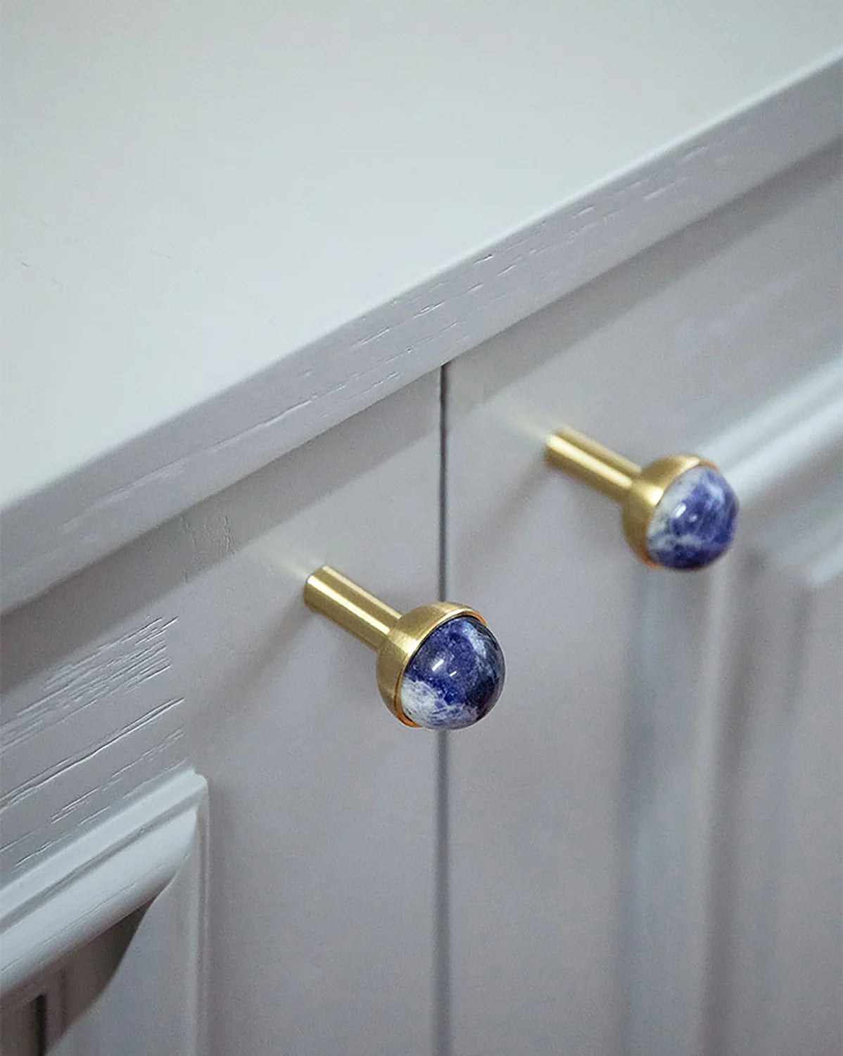 The Mantara C-0006 is a modern crystal + brass knob in blue, ideal for drawers and cabinets.