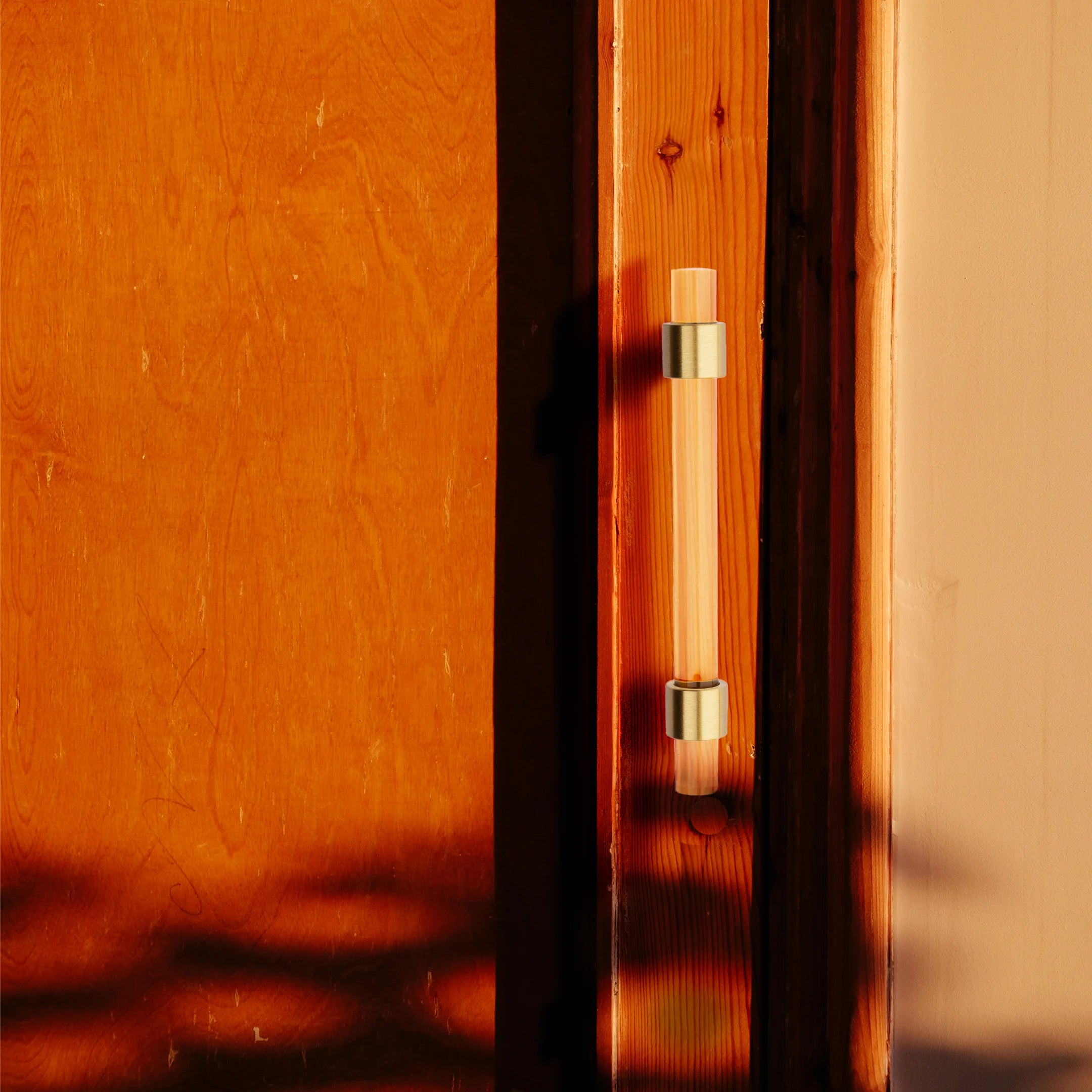 A stylish T-bar cabinet handle, Petra I made of clear acrylic and brushed brass in dark brown finish, model A-0007 by Mantara, A-0007.