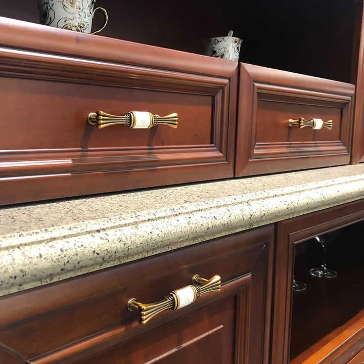 Wooden cabinet with a granite countertop and gold handles, blending natural warmth with refined detail—by Mantara.