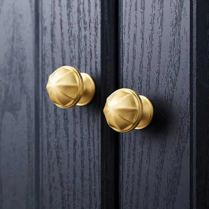 Gold door handles on a dark wooden door
