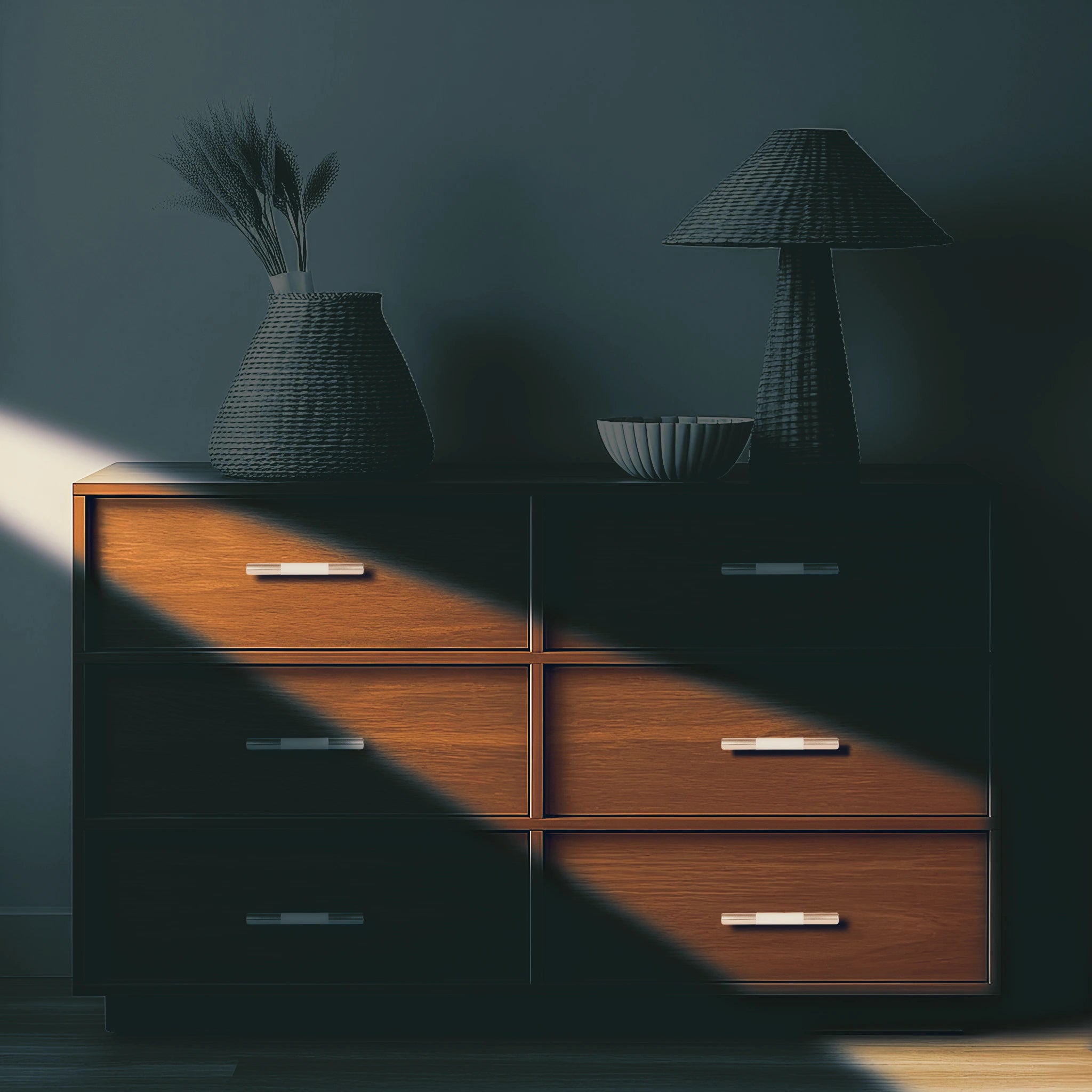 Wooden dresser with decorative items arranged on top, set against a dark wall for a warm, elegant look by Mantara.