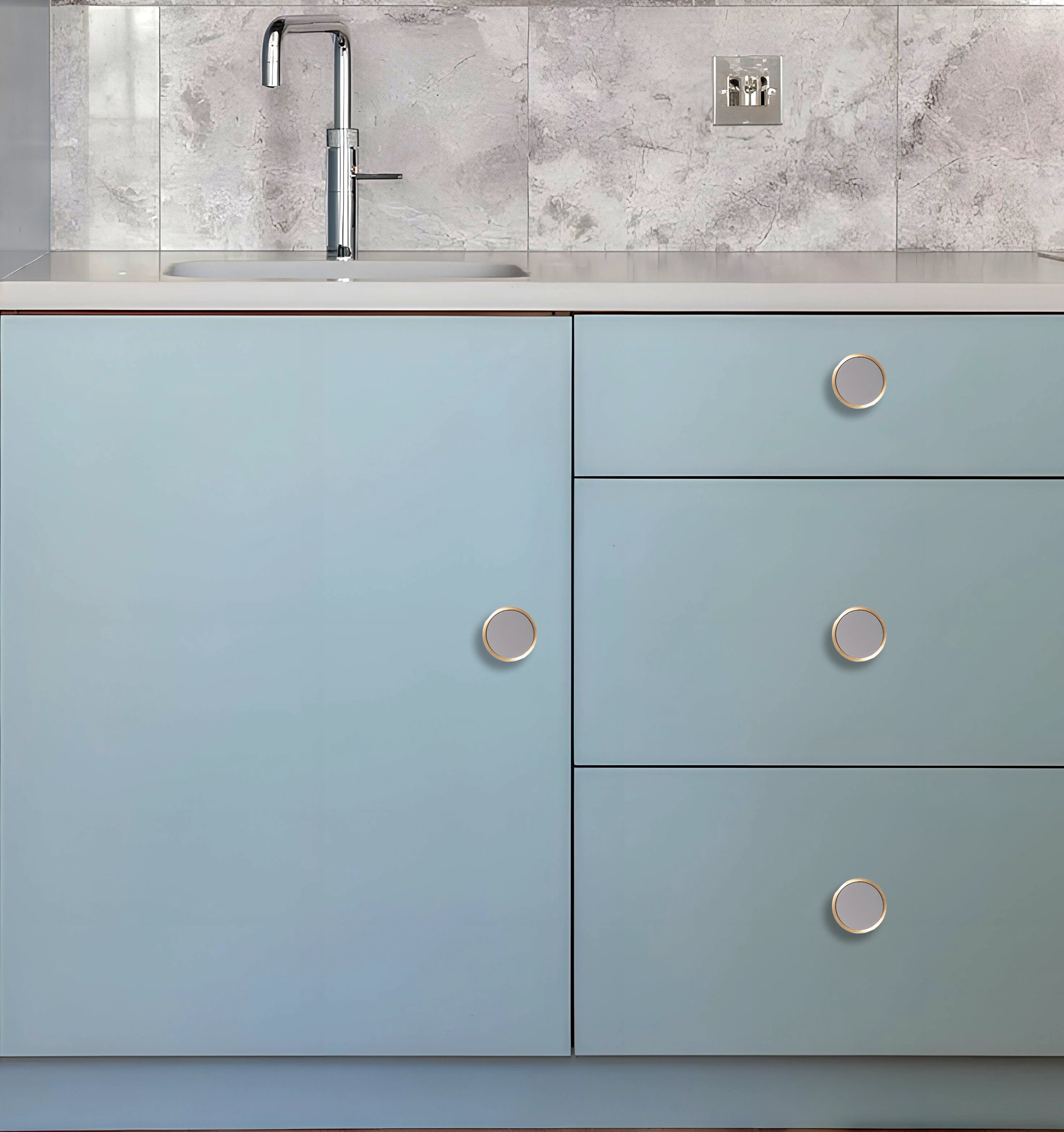 Kitchen cabinet with light blue doors and silver knobs, set against a white marble backsplash, styled by Mantara.