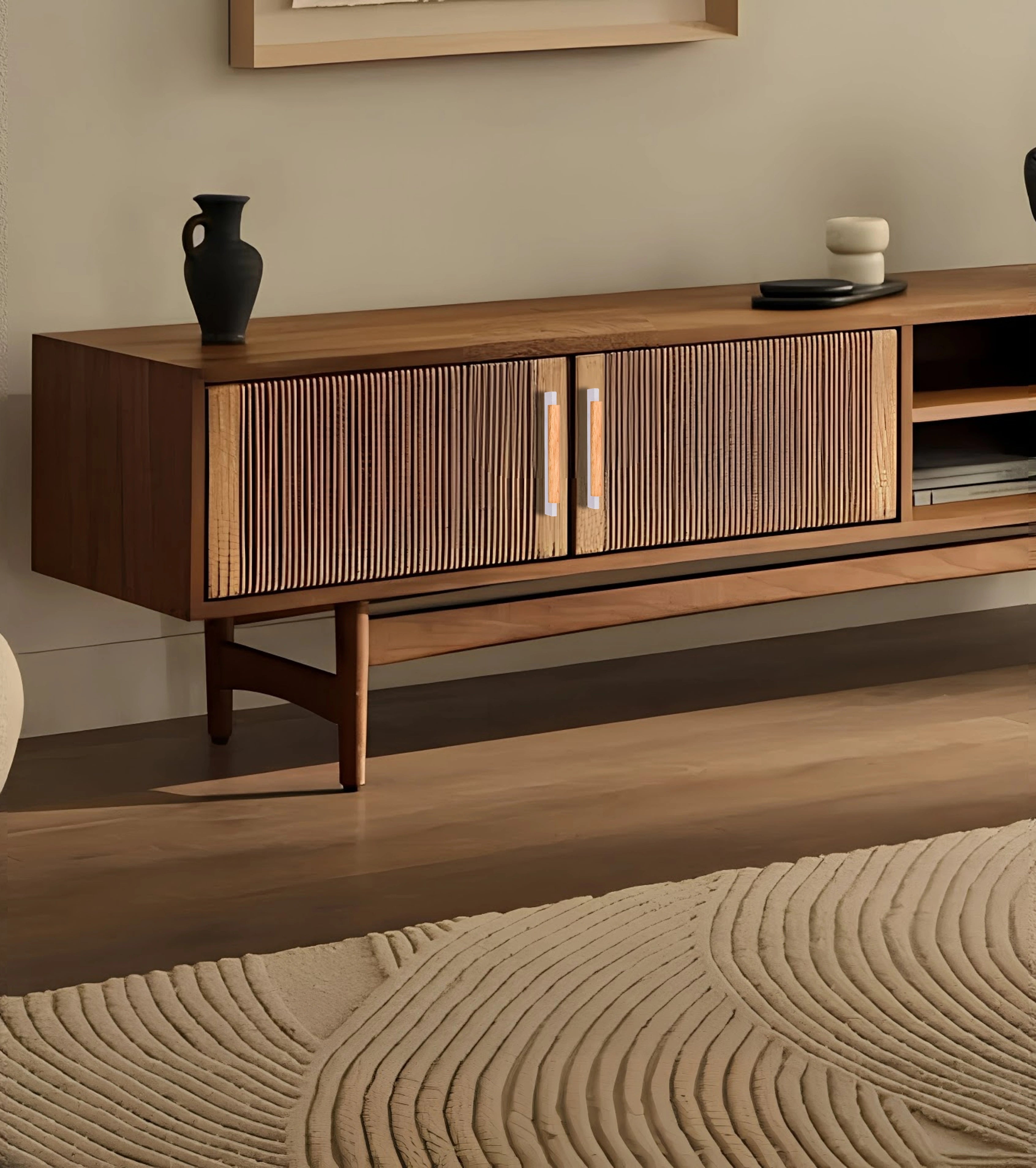 Wooden entertainment console with grey handles and decorative items, set against a soft beige wall—styled by Mantara.