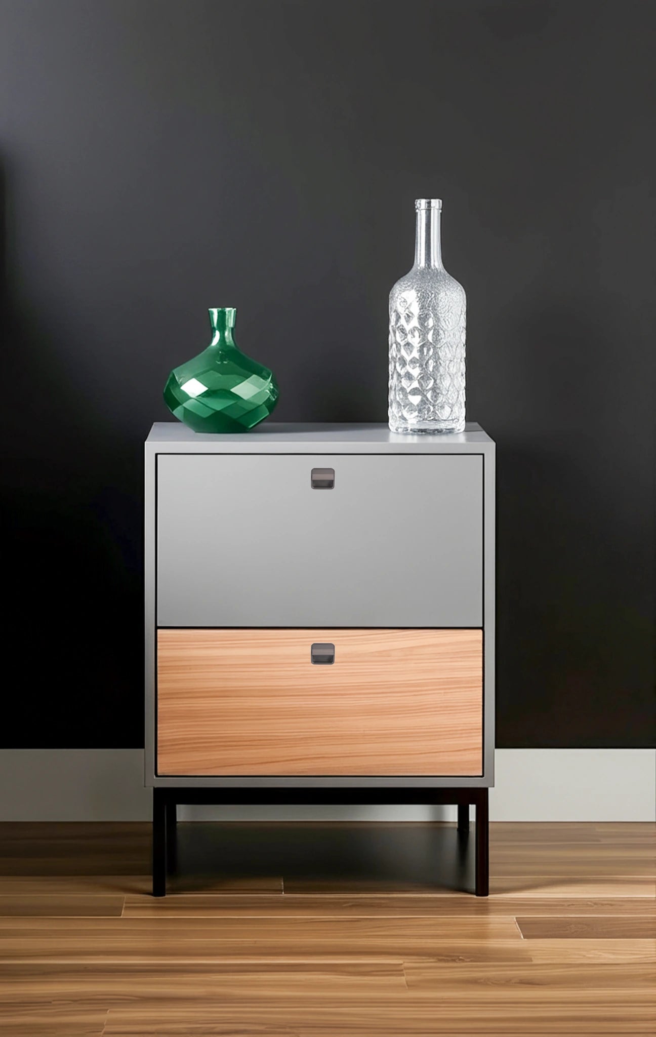 Two-toned dresser with a wooden base, gray top, and subtle knobs, styled with two decorative bottles—by Mantara.