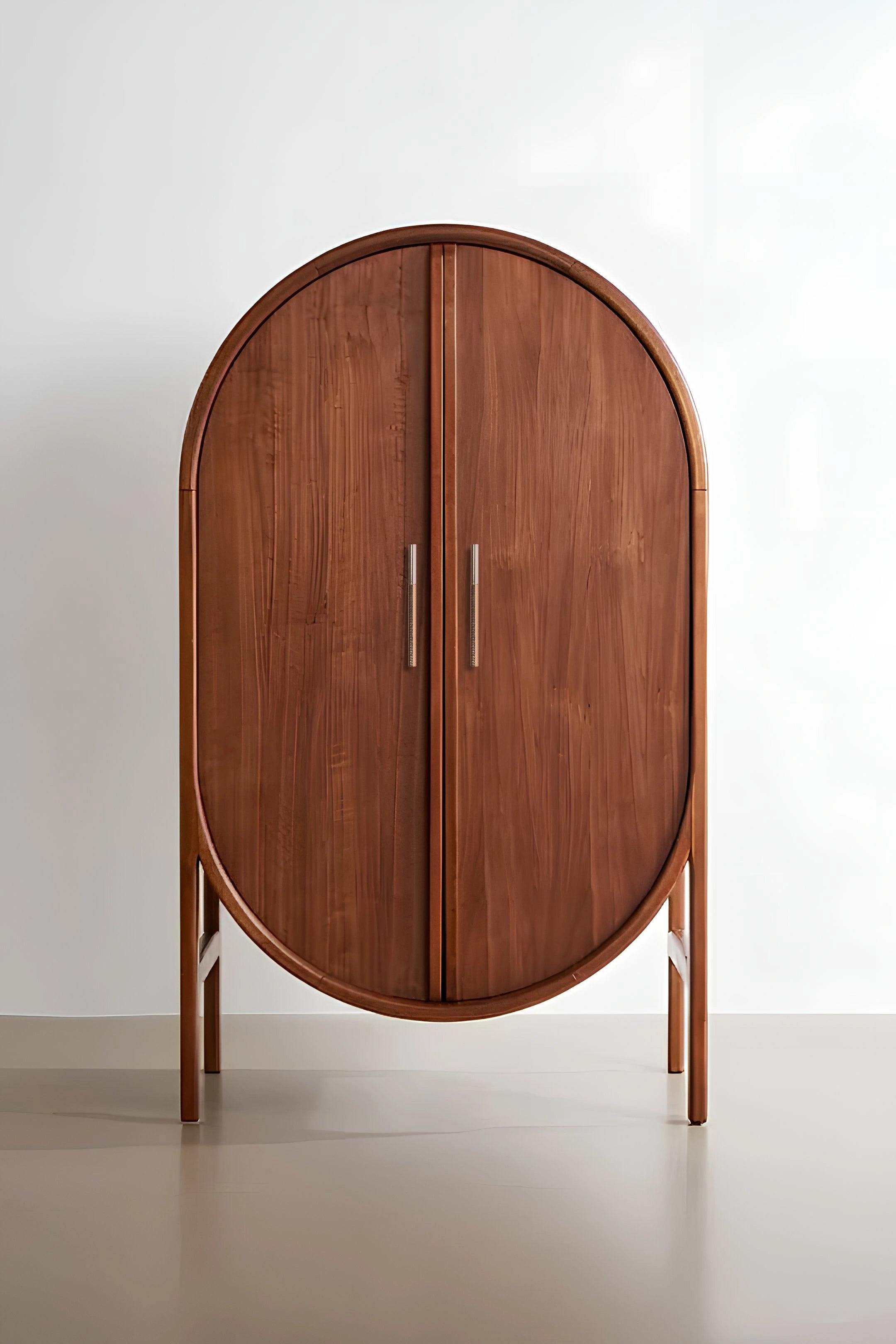 Wooden oval cabinet with two doors and rose gold handles, displayed on a clean white background—by Mantara.