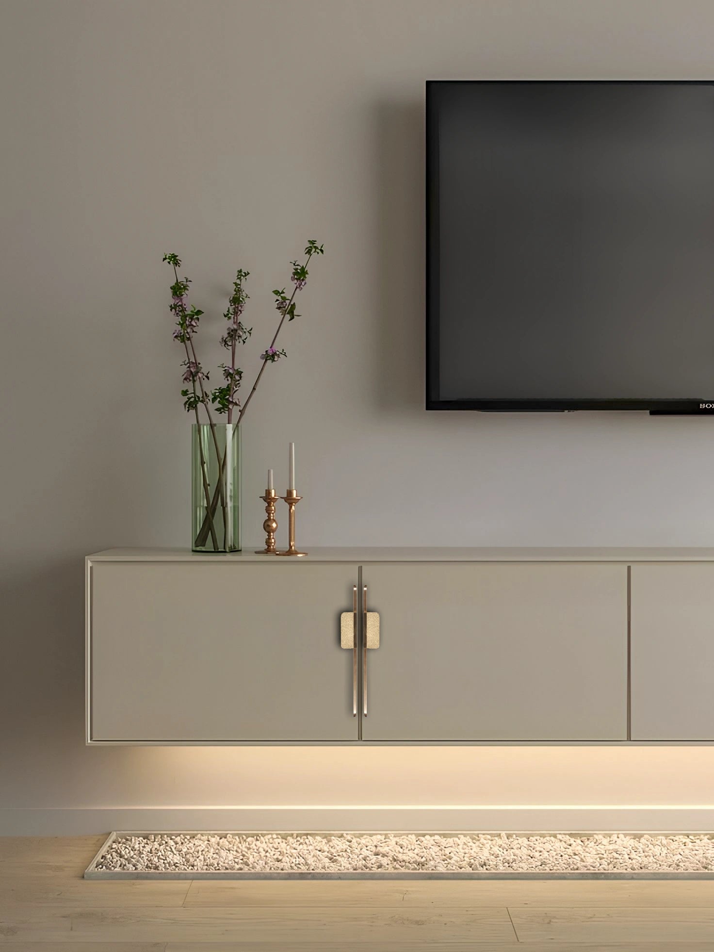 Modern living room with a light gray sideboard featuring slim handles, a television, and decor accents—by Mantara.