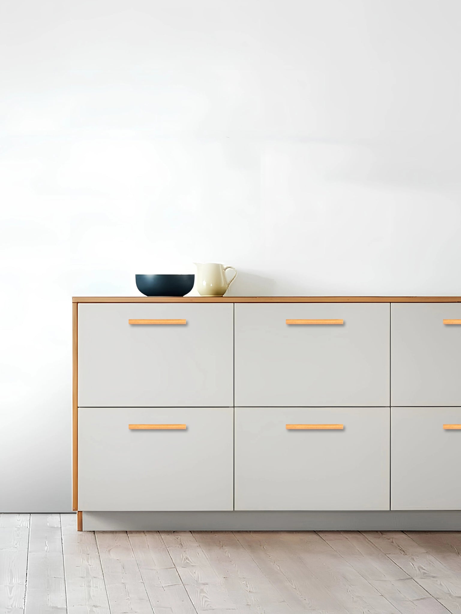 Modern dresser with light gray drawers, wooden top, and subtle handle, set against a clean white background—by Mantara.