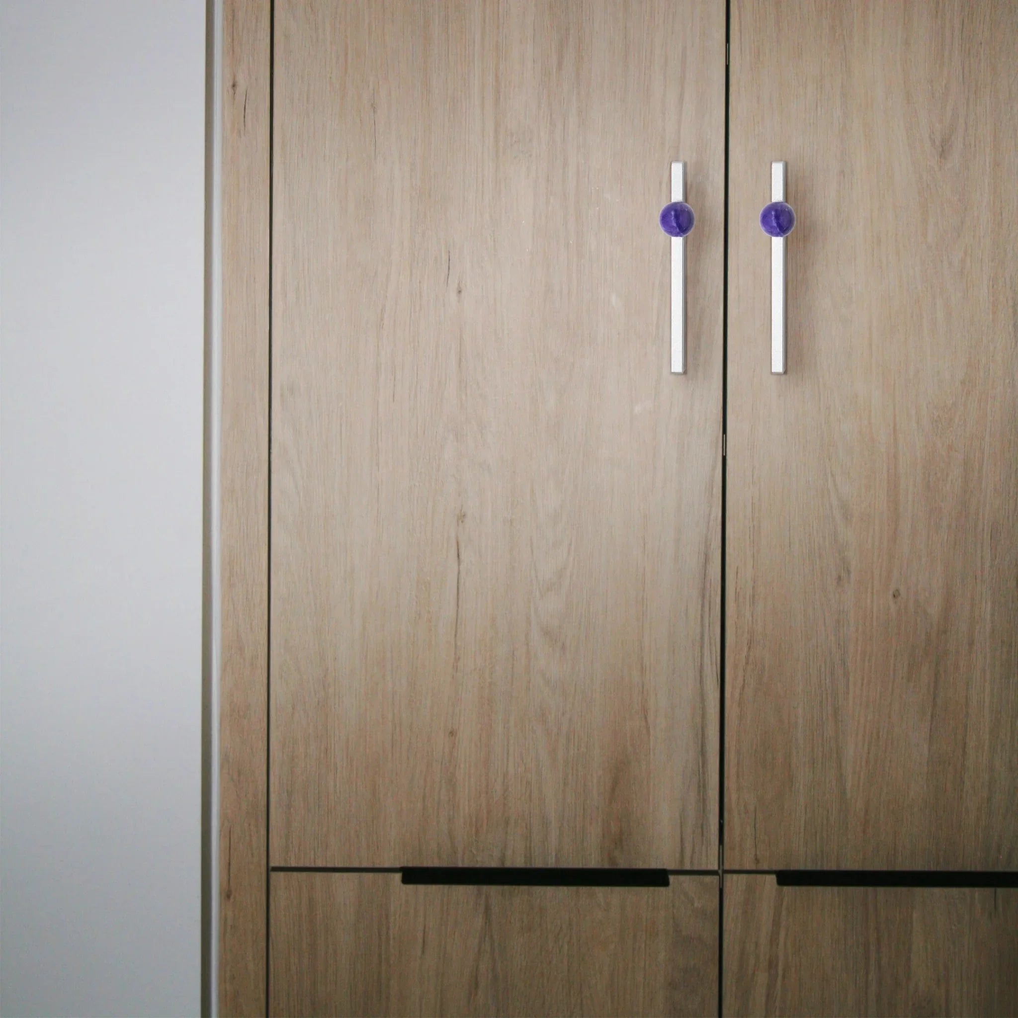 The Mantara C-0027 Calyx Handle is a modern crystal handle in silver and purple, ideal for cabinets, wardrobes, and drawers.