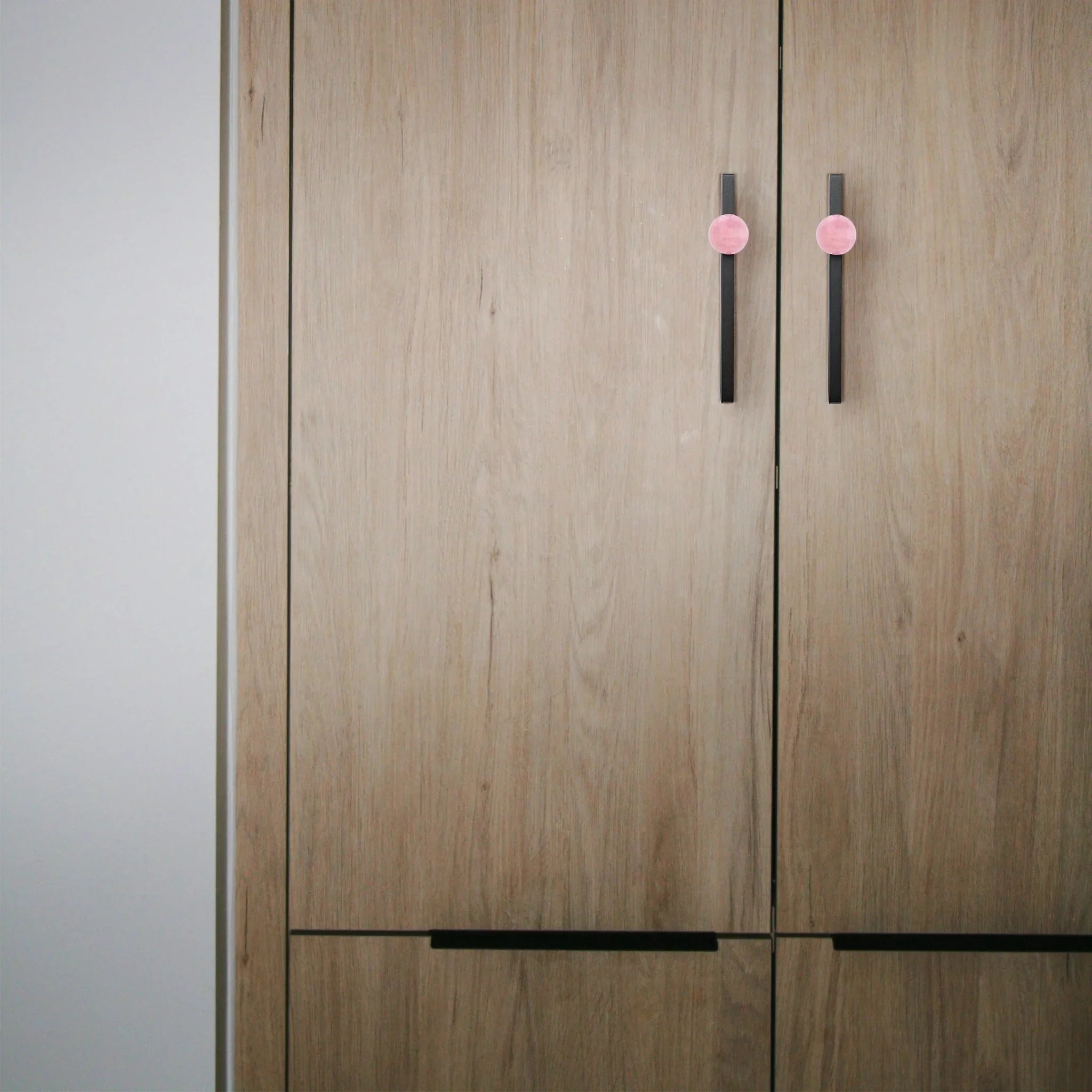 The Mantara C-0027 Calyx Handle is a modern crystal handle in black and pink, ideal for cabinets, wardrobes, and drawers.