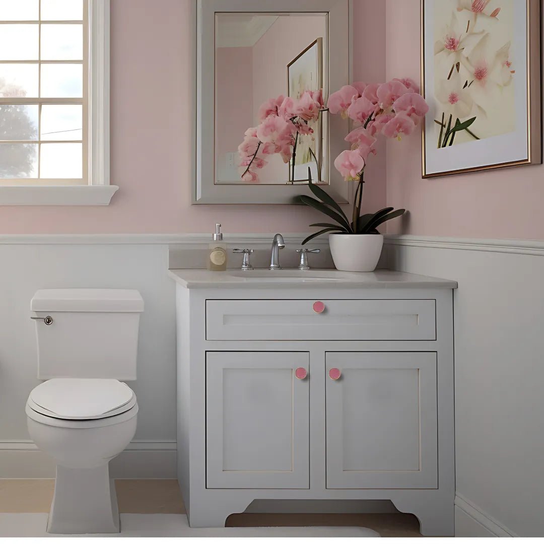 A bathroom featuring pink walls and white cabinets, creating a bright and cheerful atmosphere, designed by mantara