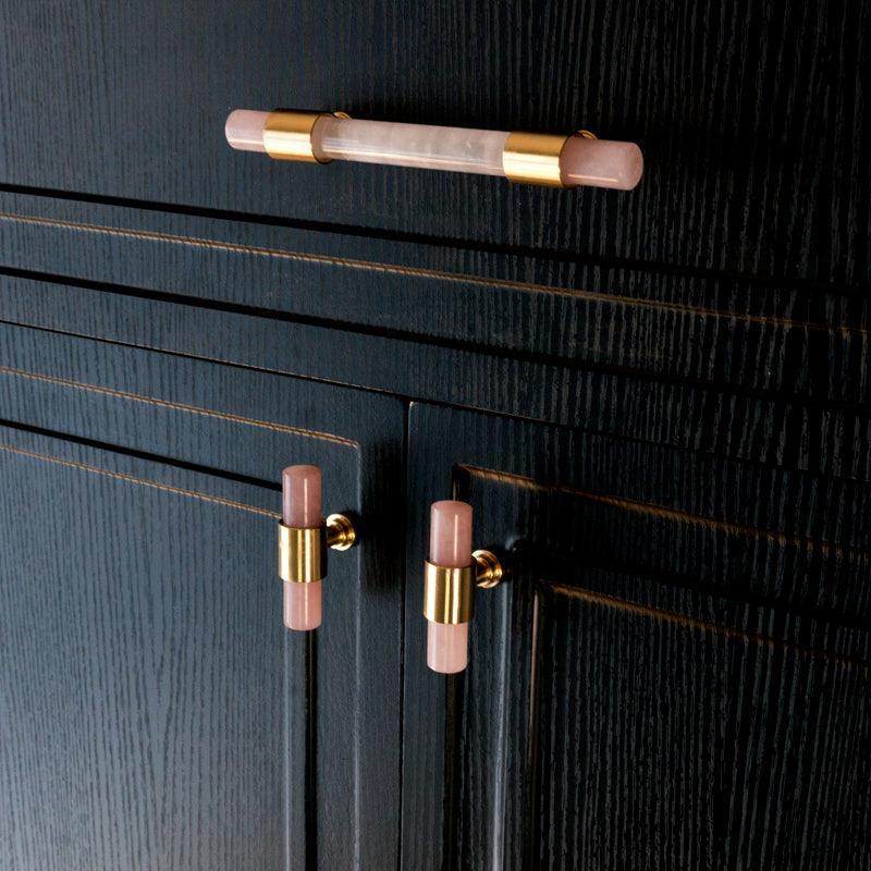 The Mantara C-0014-T Haze Handle is a modern crystal and brass T-handle in pink, ideal for wardrobes and drawers.