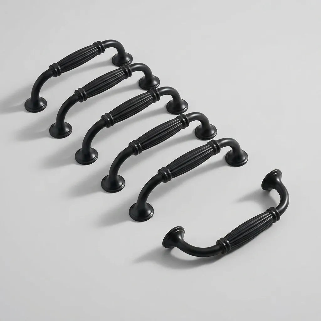 Six black metal cabinet handles arranged diagonally on a light gray background.