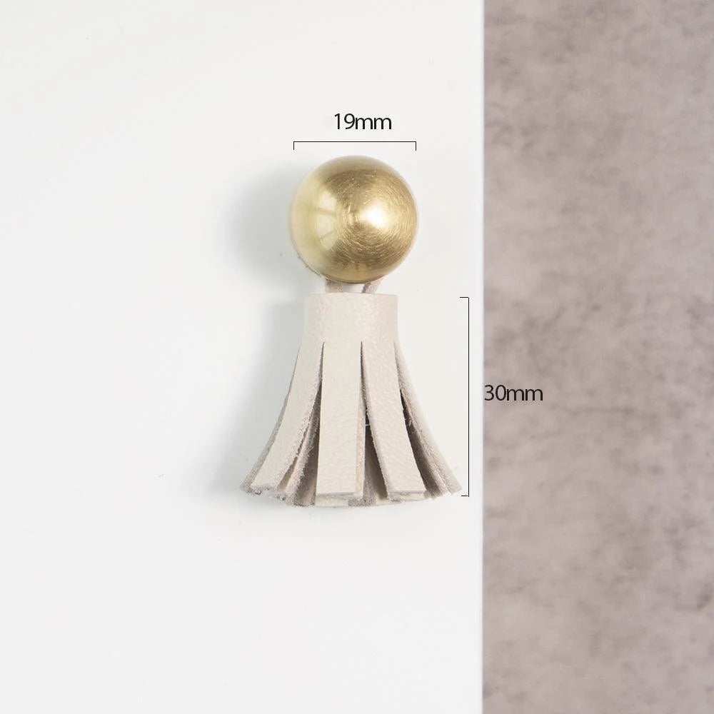 The Mantara L-0002 Maverick Drop Knob is a modern leather and brass knob in white, ideal for kitchens and furniture.
