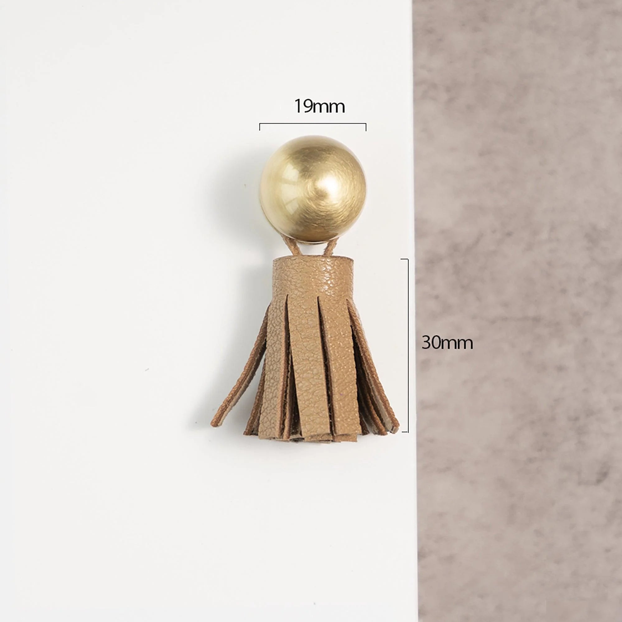 The Mantara L-0002 Maverick Drop Knob is a modern leather and brass knob in brown, ideal for kitchens and furniture.