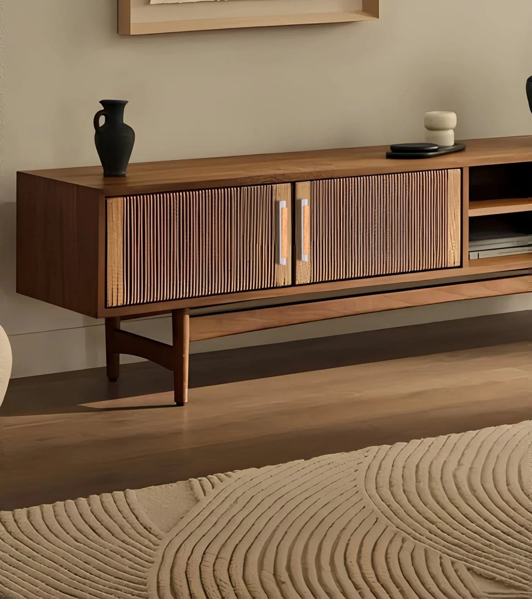 Wooden entertainment console with grey handles and decorative items, set against a soft beige wall—styled by Mantara.