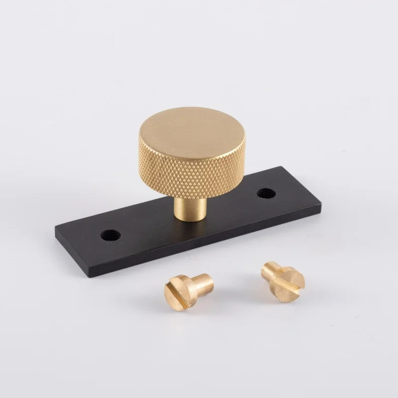 The Mantara B-0118 is a modern brass knob in gold with a black stabiliser base, ideal for kitchen and dresser drawers.