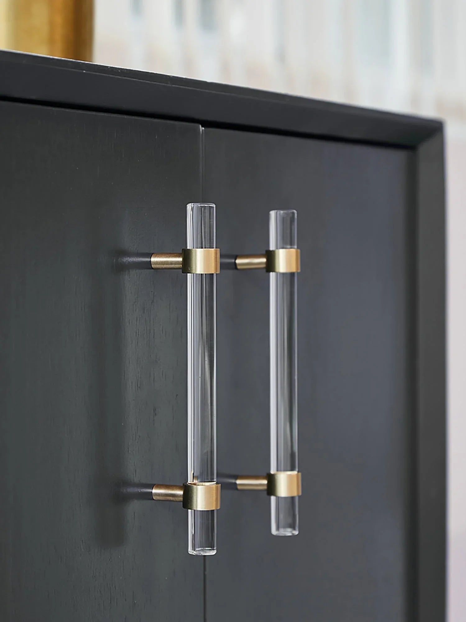A sleek T-bar handle, Petra II made of clear acrylic with brushed brass supports in transparent white finish, model A-0008 by Mantara, A-0008.