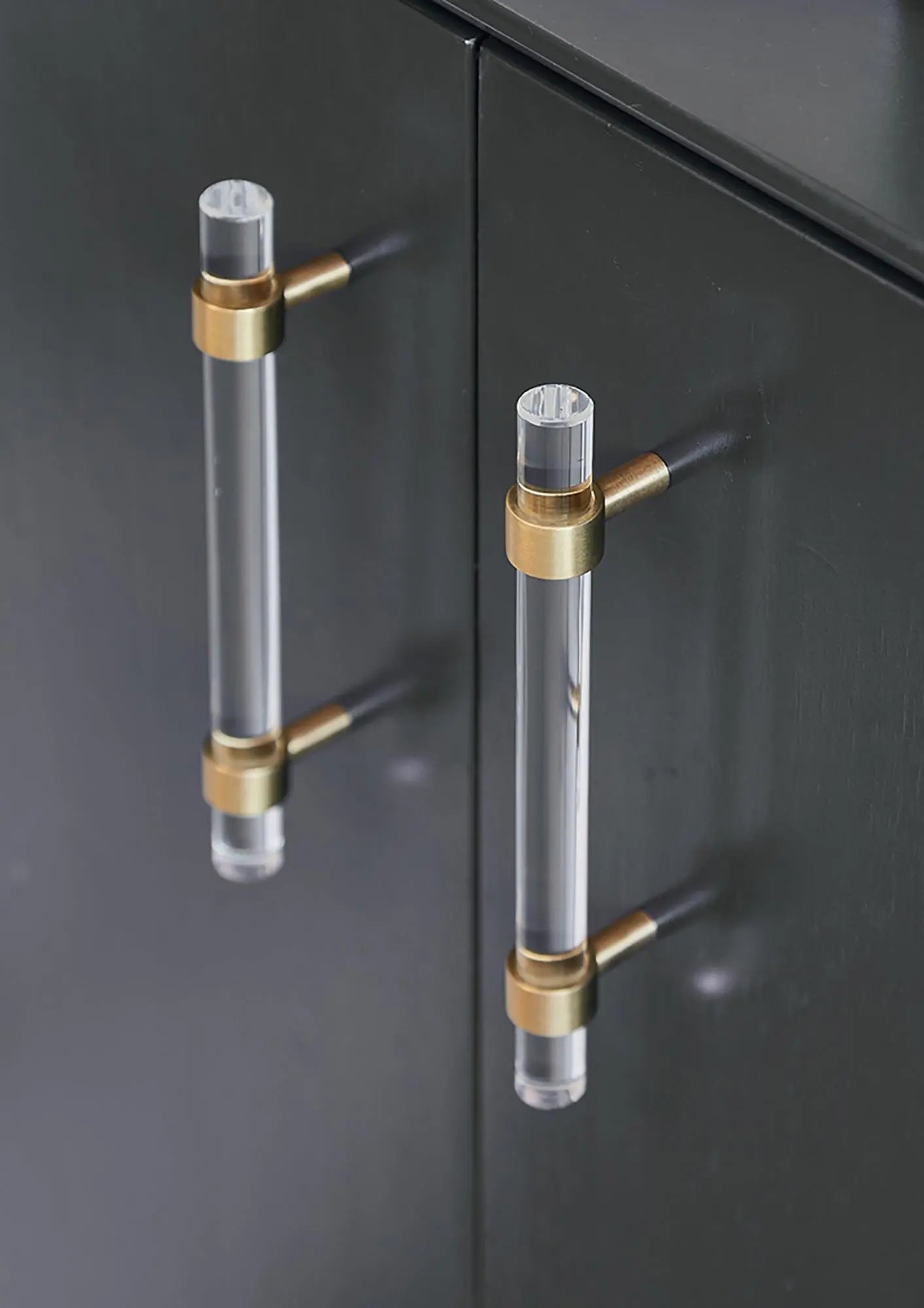 A sleek T-bar handle, Petra II made of clear acrylic with brushed brass supports in transparent white finish, model A-0008 by Mantara, A-0008.