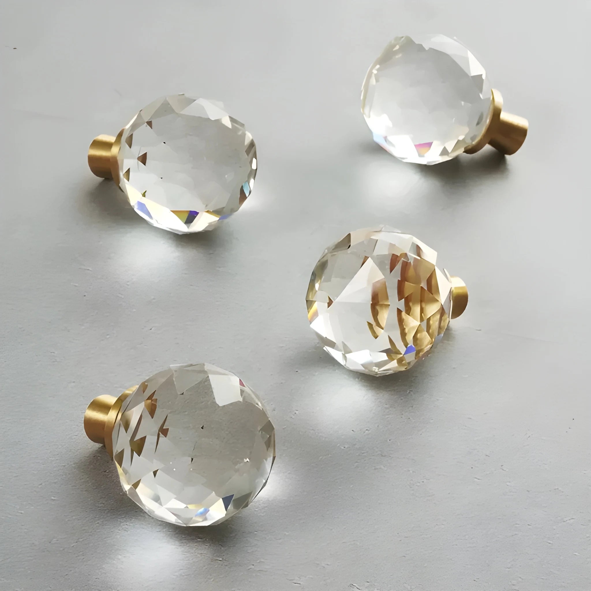 The Mantara C-0016 Quartz Handle is a modern crystal knob in white with polished brass, ideal for wardrobes, cabinets, and kitchens.