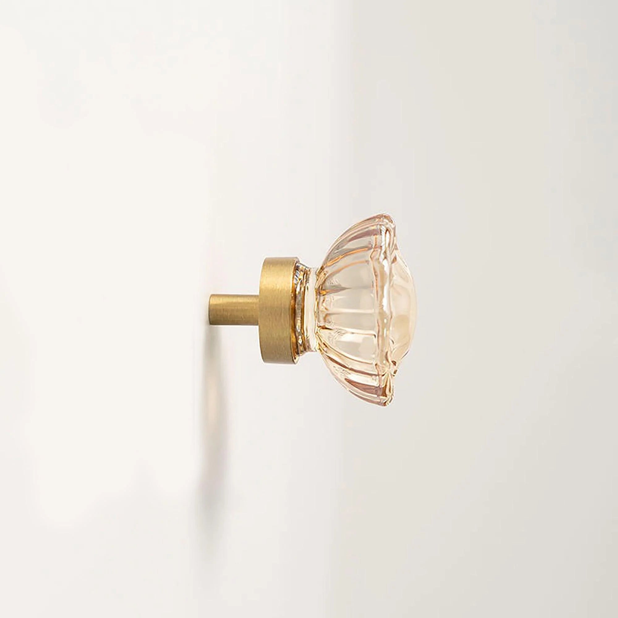The Mantara C-0018 Ripple Knob is a modern crystal and brass knob in champagne finishes, ideal for kitchens and cabinets.