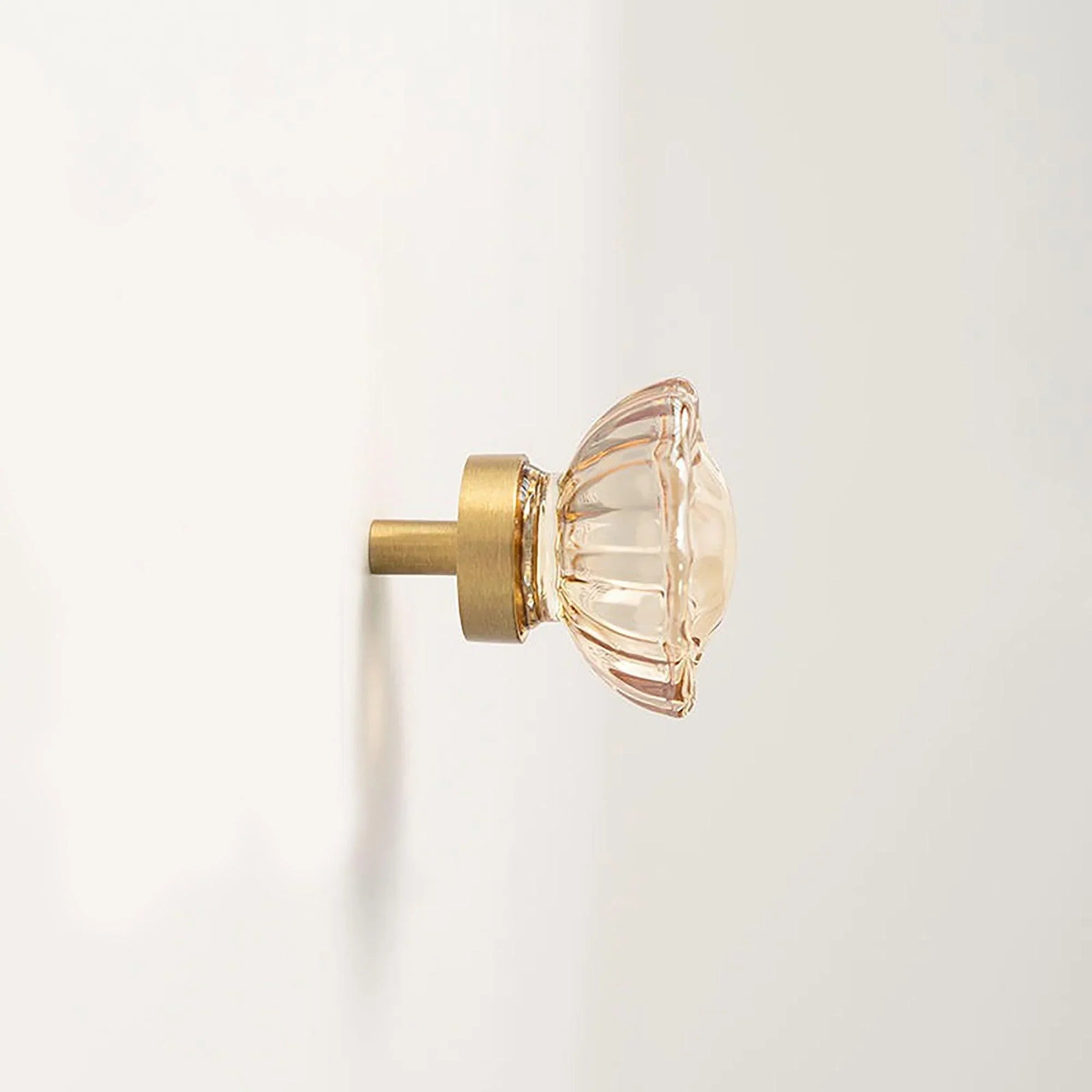 The Mantara C-0018 Ripple Knob is a modern crystal and brass knob in champagne finishes, ideal for kitchens and cabinets.
