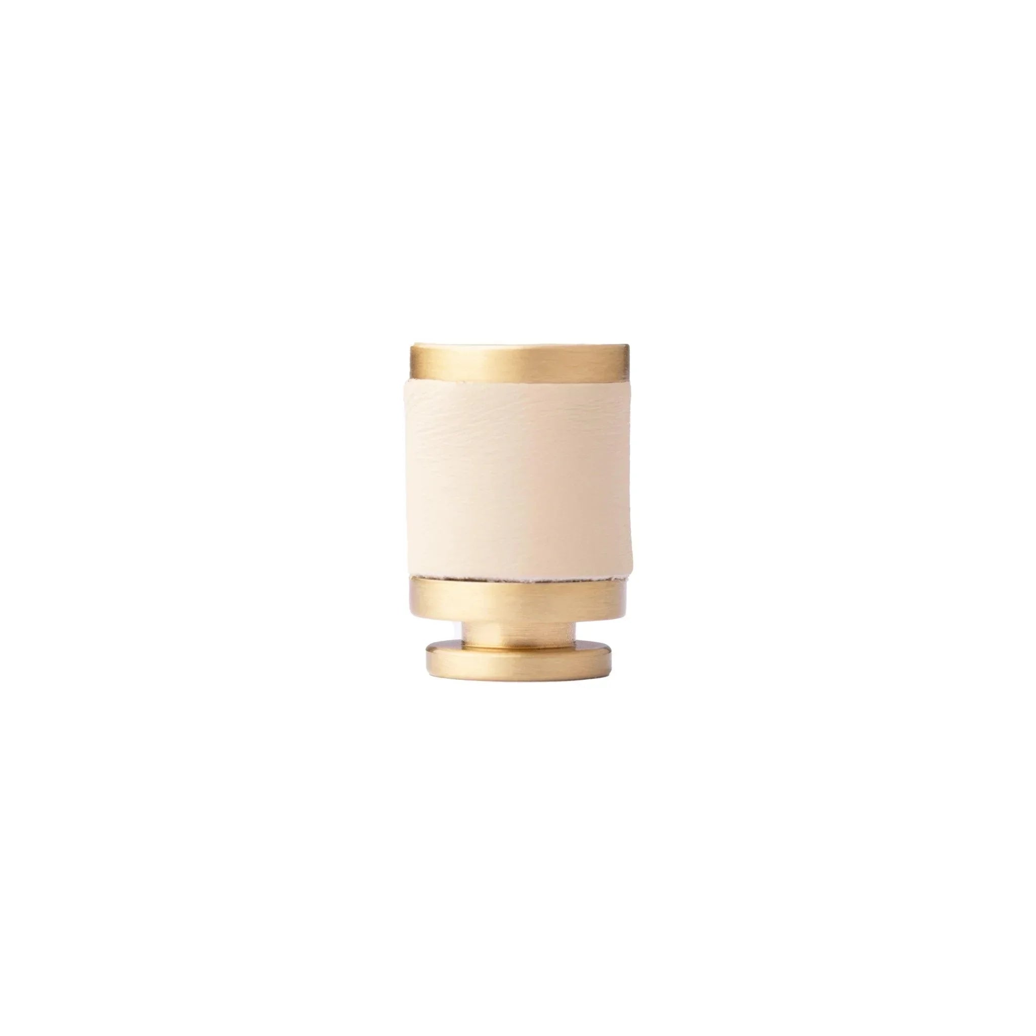 The Mantara L-0003 Tanner Knob is a modern brass and leather knob in white, perfect for cabinets and furniture.