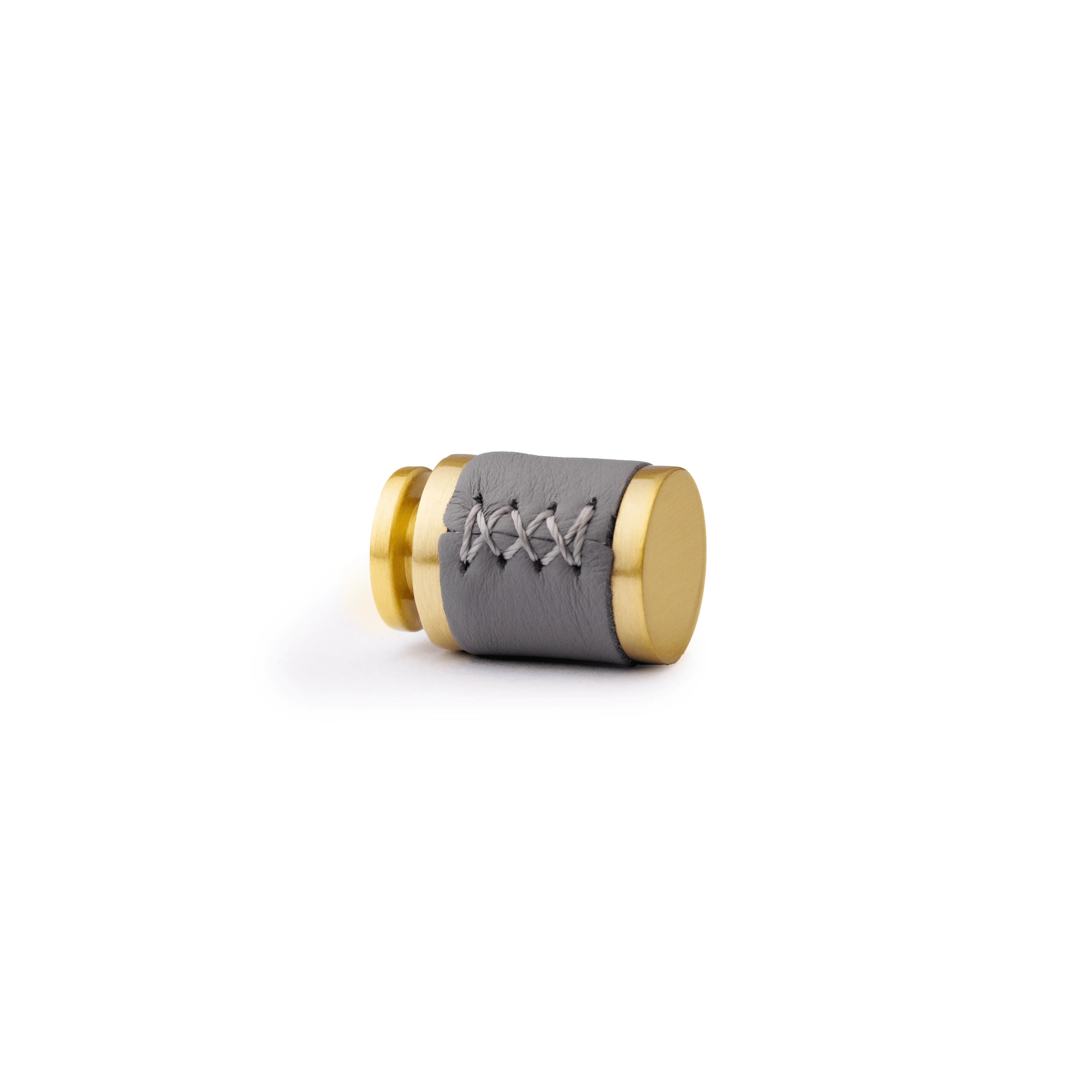 The Mantara L-0003 Tanner Knob is a modern brass and leather knob in grey, perfect for cabinets and furniture.
