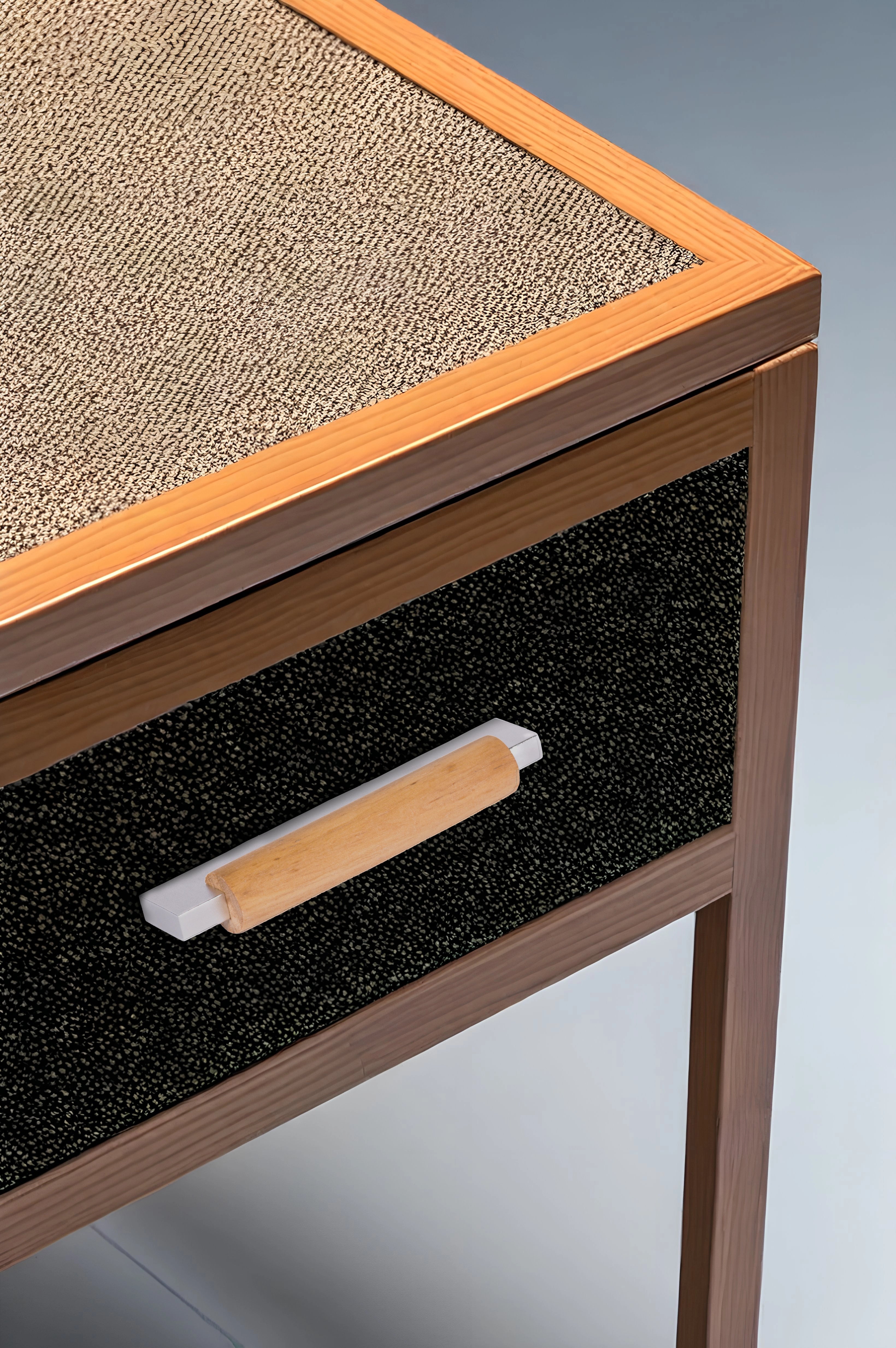 Wooden side table with a textured top and black drawer featuring a wooden handle—contrasting materials by Mantara.