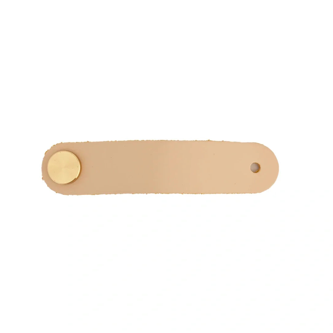 The Mantara L-0001 Maverick Pull Knob is a Nordic leather and brass knob in cream, ideal for kitchens and furniture.