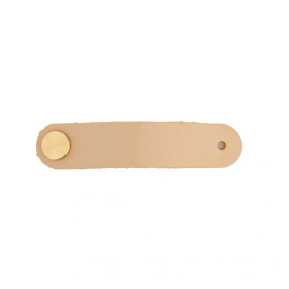 The Mantara L-0001 Maverick Pull Knob is a Nordic leather and brass knob in cream, ideal for kitchens and furniture.
