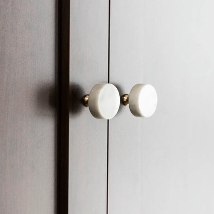 The Mantara M-0001 Theo Knob is a modern marble and brass knob in white, ideal for doors, drawers, and cabinets.
