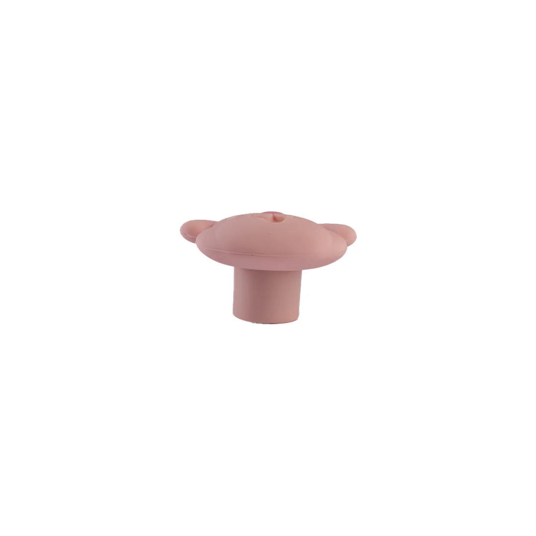 A single small pink silicone with a rounded top, two small side tabs, and a short cylindrical base, centered on a plain white background.