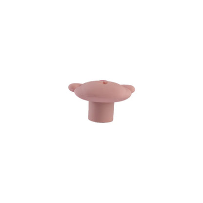 A single small pink silicone with a rounded top, two small side tabs, and a short cylindrical base, centered on a plain white background.