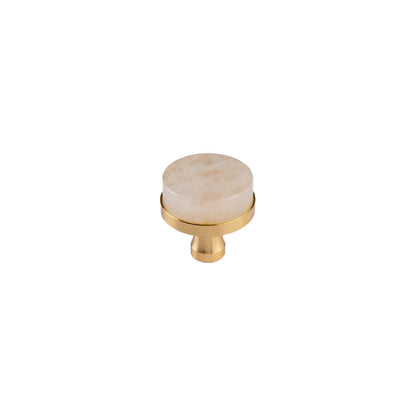A single round cabinet knob featuring a polished cream-colored stone top with subtle crystal, mounted on a brushed gold brass