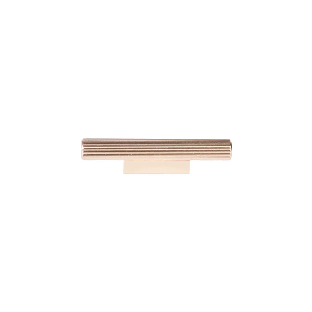 A modern horizontal cabinet pull handle with a textured, ribbed top bar and a solid rectangular base, finished in a warm rose gold tone, shown on a plain white background.