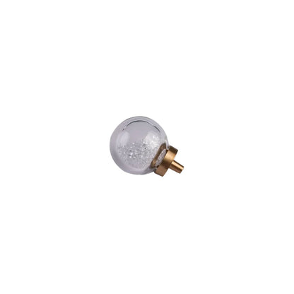 A small decorative glass globe with clear glittery contents and a gold-toned metal cap, isolated on a plain white background.
