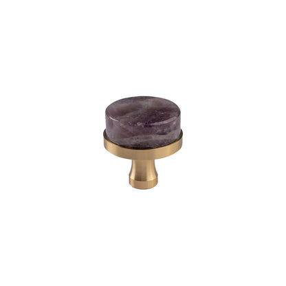 A round cabinet knob featuring a polished purple amethyst stone top and a brushed brass base, shown against a plain white background.