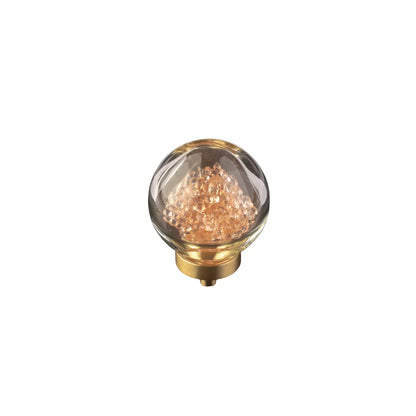 A decorative glass globe light bulb with a gold-toned metal base, filled with shimmering rose-gold or copper-colored crystals, shown on a plain white background.