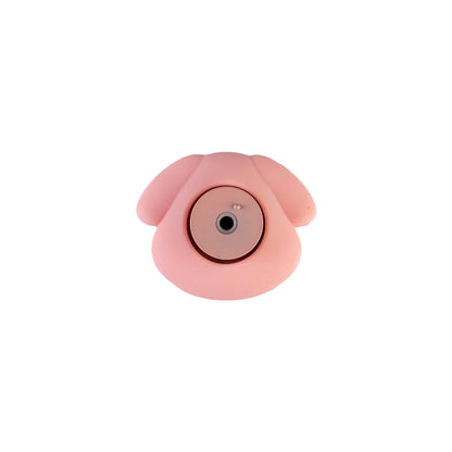 A pink, dog-shaped silicone camera lens protector or cover with a circular center opening, shown against a plain white background.