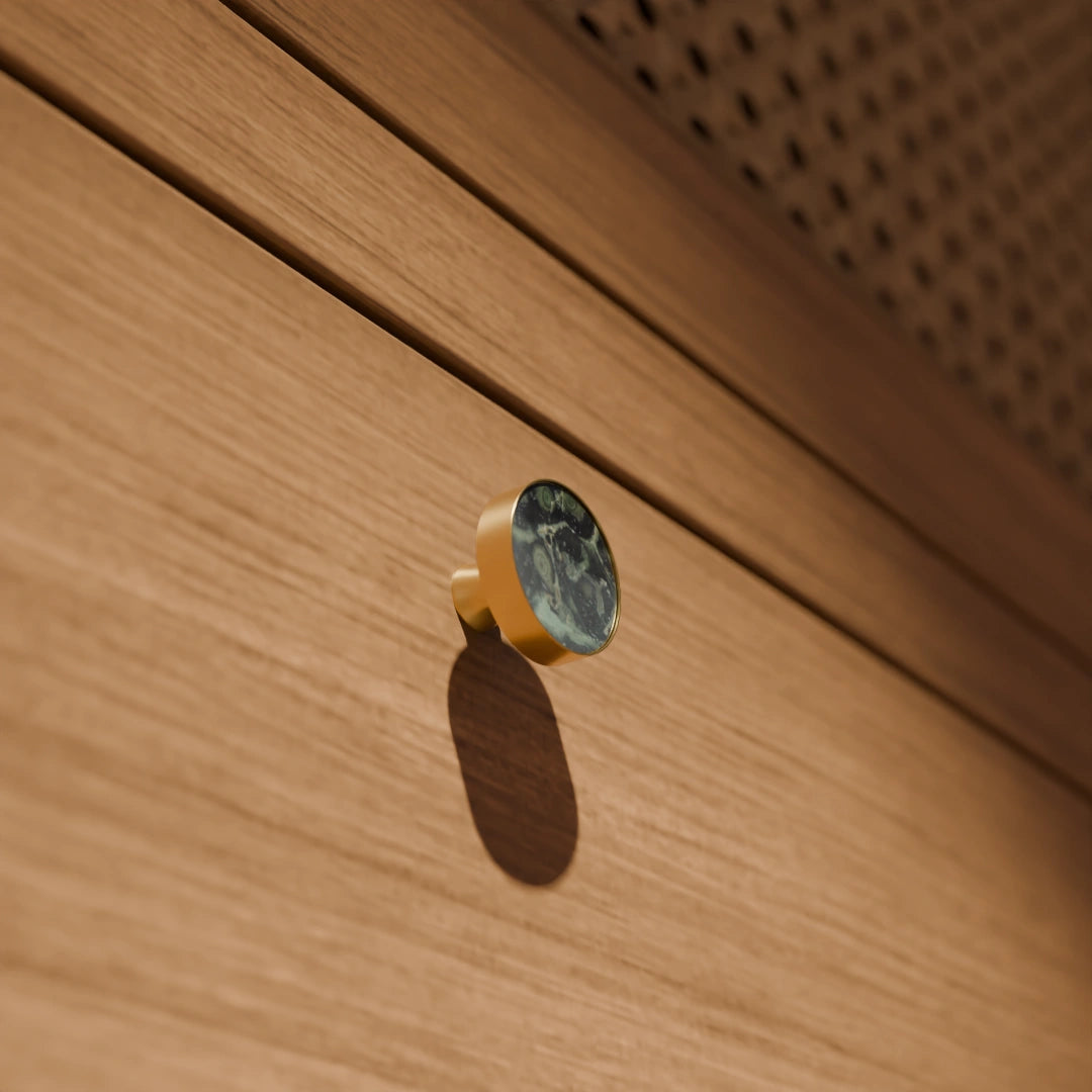 The Mantara M-0004 Carrara Knob is a modern stone and brass knob in Peacock stone, ideal for drawers and cabinets.