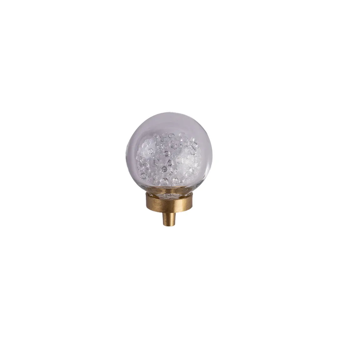 A spherical glass decorative light fixture with clear textured internal details and a gold metal base, shown against a plain white background.