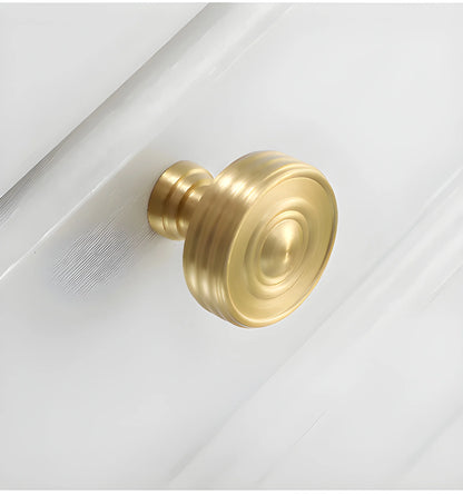 The Mantara B-0121 is a modern brass knob in gold with a brushed finish, ideal for kitchen drawers and dressers.