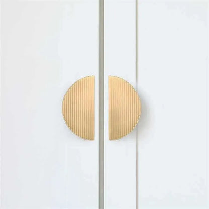 Gold circular door handles mounted on a white door, creating a clean and stylish contrast, designed by Mantara.