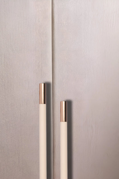 Close-up of a textured wall with two metallic handles, set against a neutral background, offering subtle detail by Mantara.