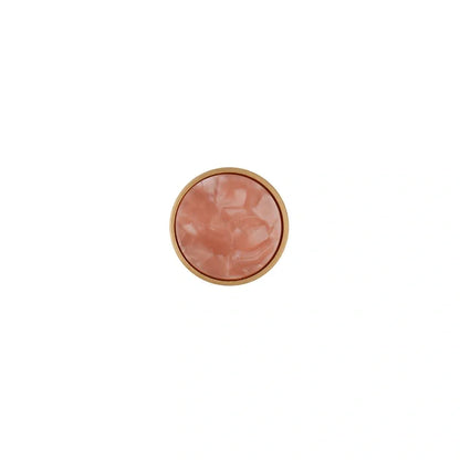 Round pink object with a gold rim on a white background