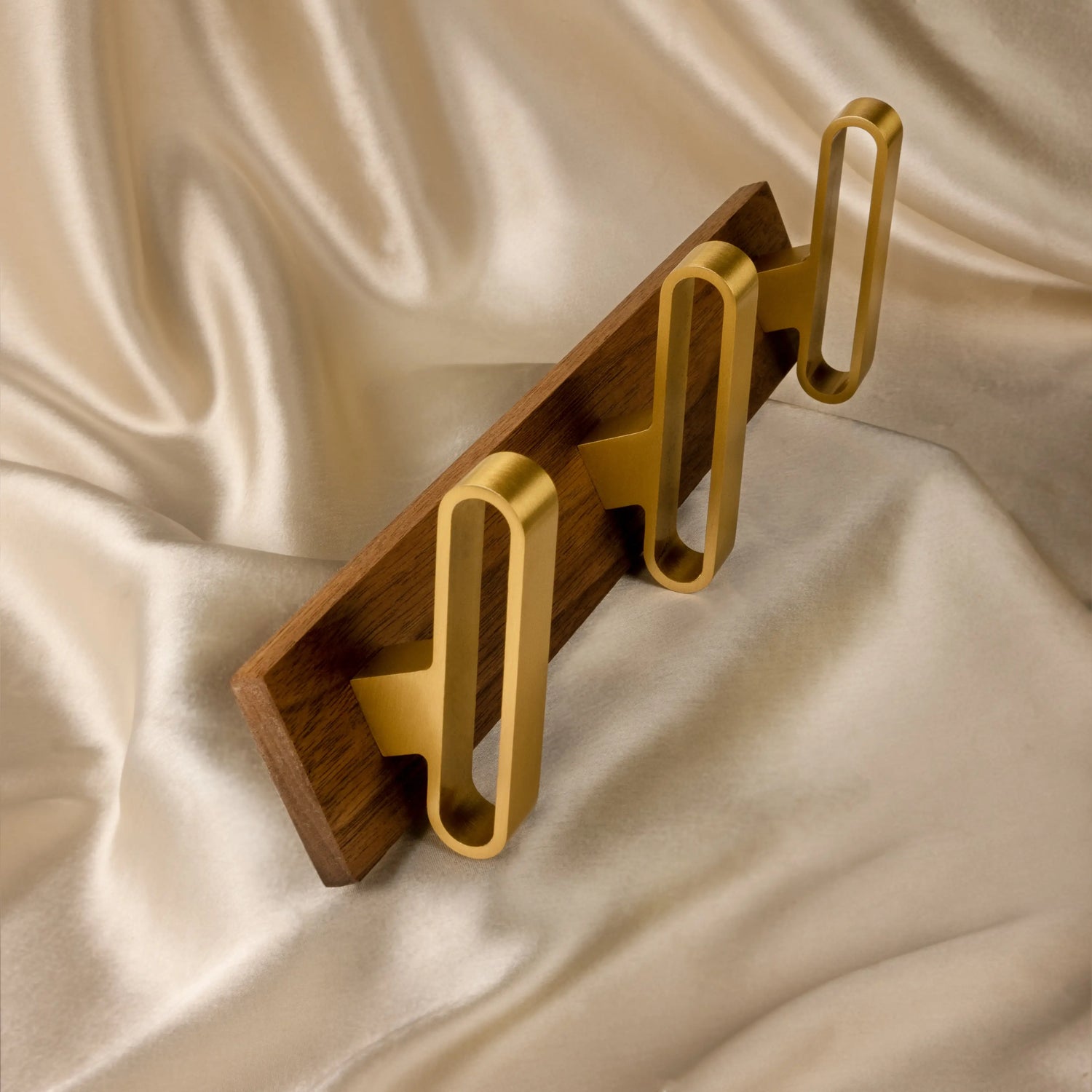 Wall hook made of walnut wood with brass hardware in gold finish by Mantara, model W-0012.