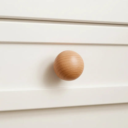 Cherry Wooden knob on a white cabinet